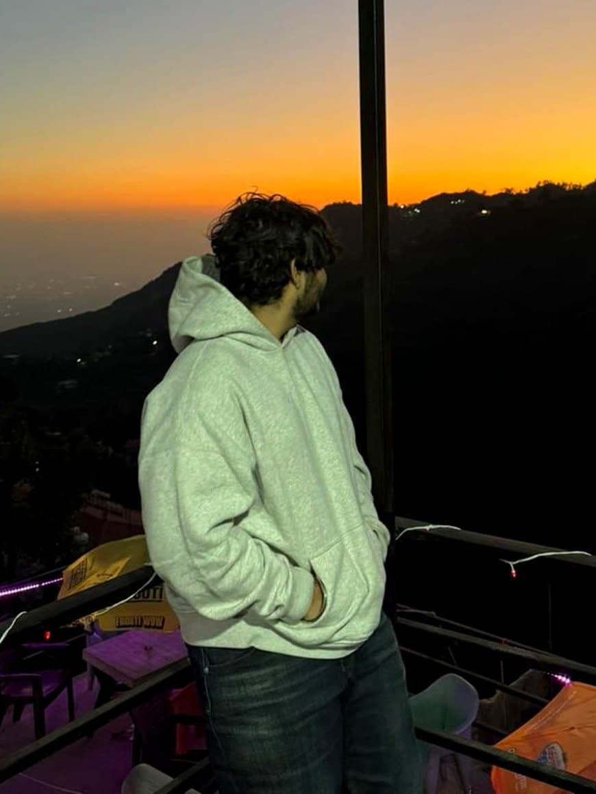 Rudra Gupta watching a golden-hour sunset from a hillside terrace